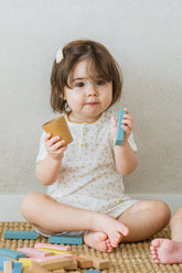AVAUMA baby girl eating snack in lemon butter floral pajama set